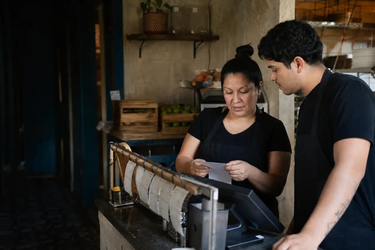 A local restaurant owner and employee checking orders at a working counter